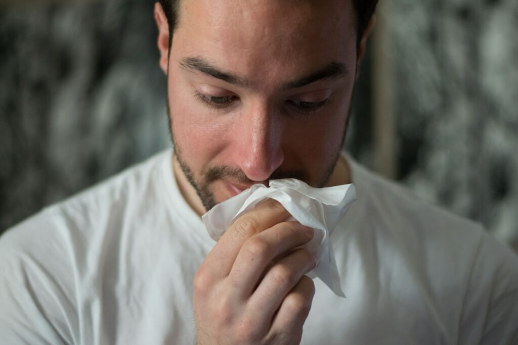 A man wiping his nose.