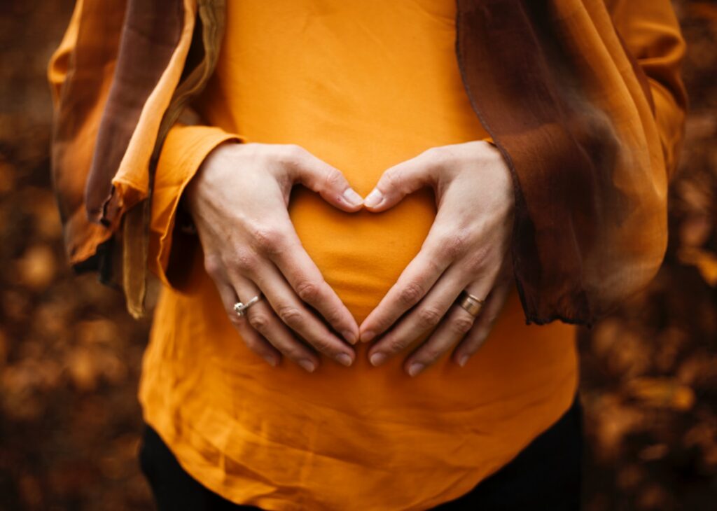 heart symbol over woman holding stomach due to pain