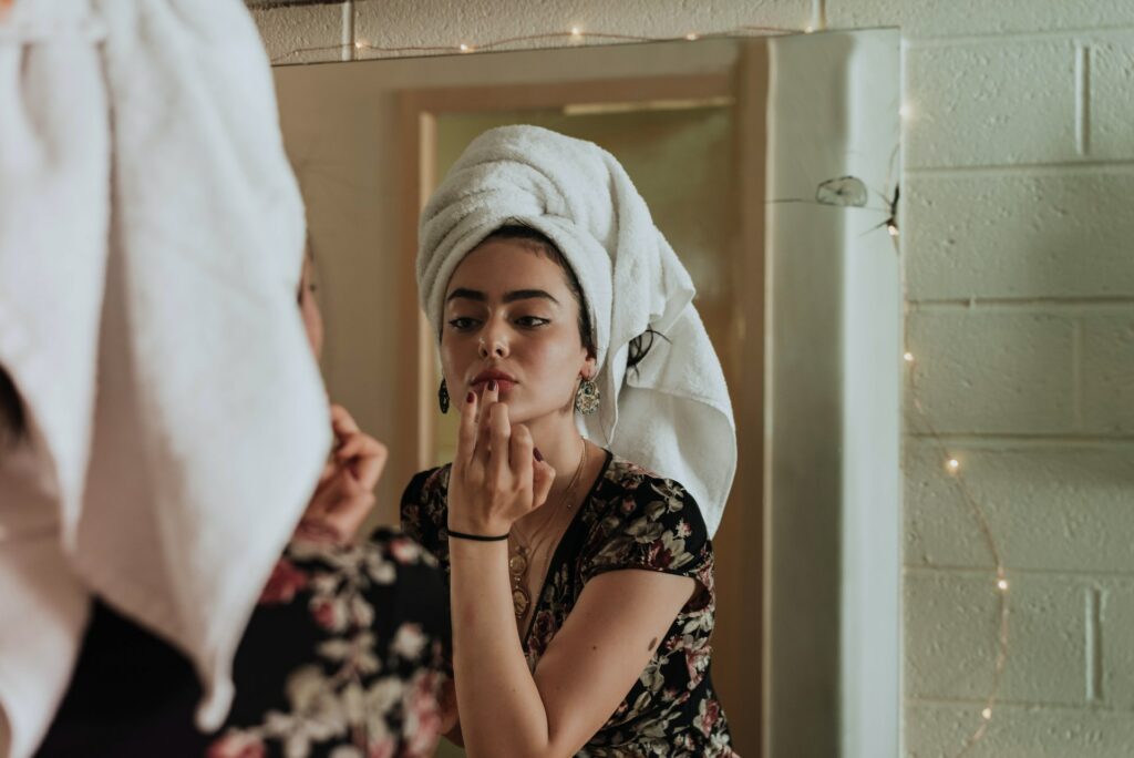 A women looking in the mirror to apply skin care prodcuts