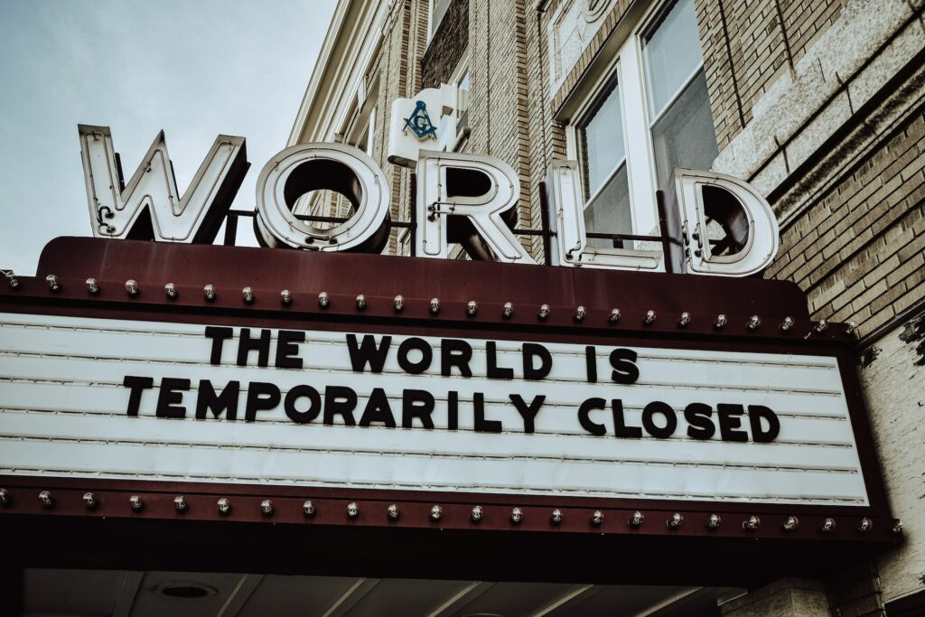 Picture of a cinema advertising board with the text "the world is temporarily closed"